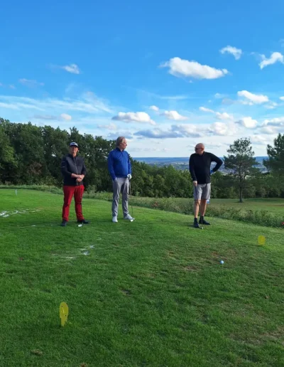 Toe aan een retraite in het buitenland? Hier zien we drie mannen aan het golfen in een rustige omgeving